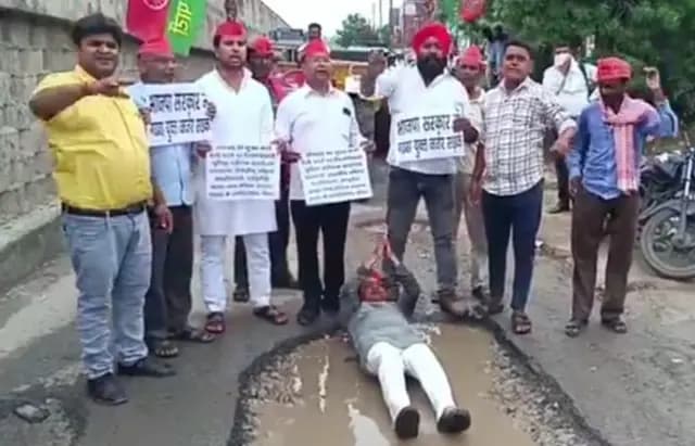 Sonbhadra News : फ्लाईओवर के सर्विस लेन की हालत बदहाल, पानी से भरे गड्ढों में बैठकर सपाइयों ने किया अनोखा प्रदर्शन